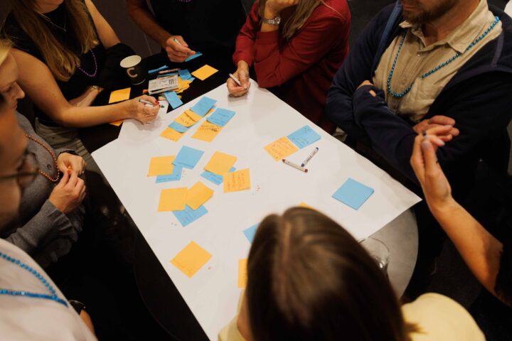 People brainstorming with sticky notes on a table.