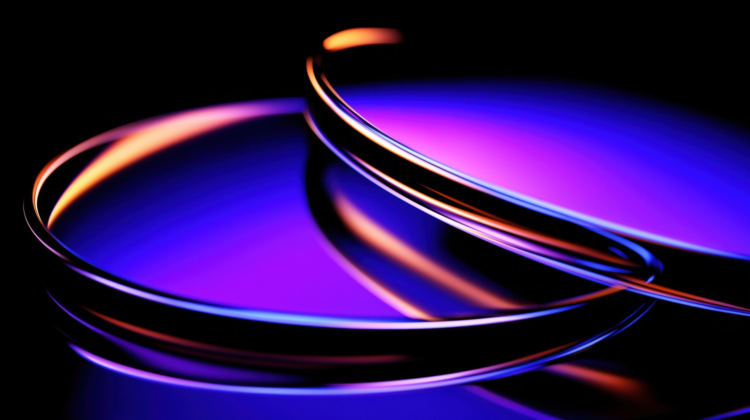 Abstrakt bild med två ljusringar i lila, blått och orange, mot en svart bakgrund.