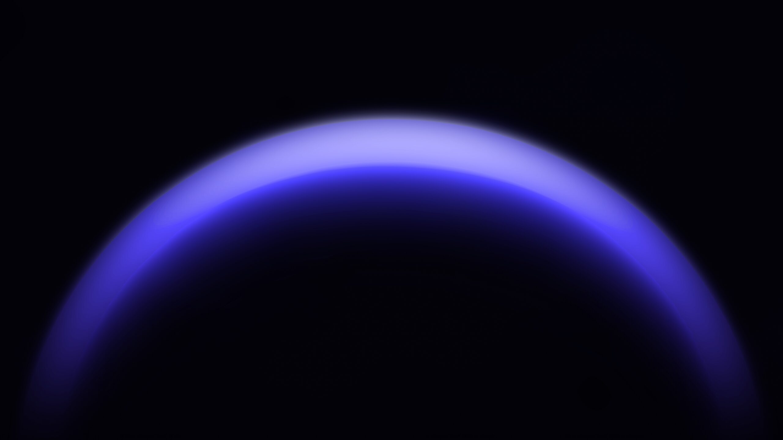 A glowing blue arc fades into darkness, resembling a planet’s horizon against a black background.