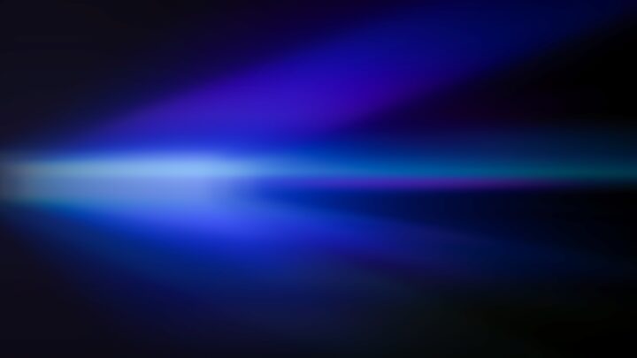 Abstract blurred blue and purple light streaks on a dark background.