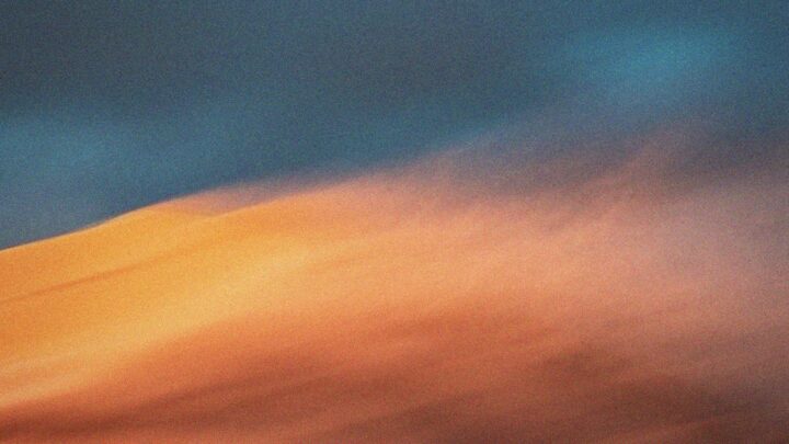 Abstract image with blurred blue and orange colours blending diagonally across the frame.